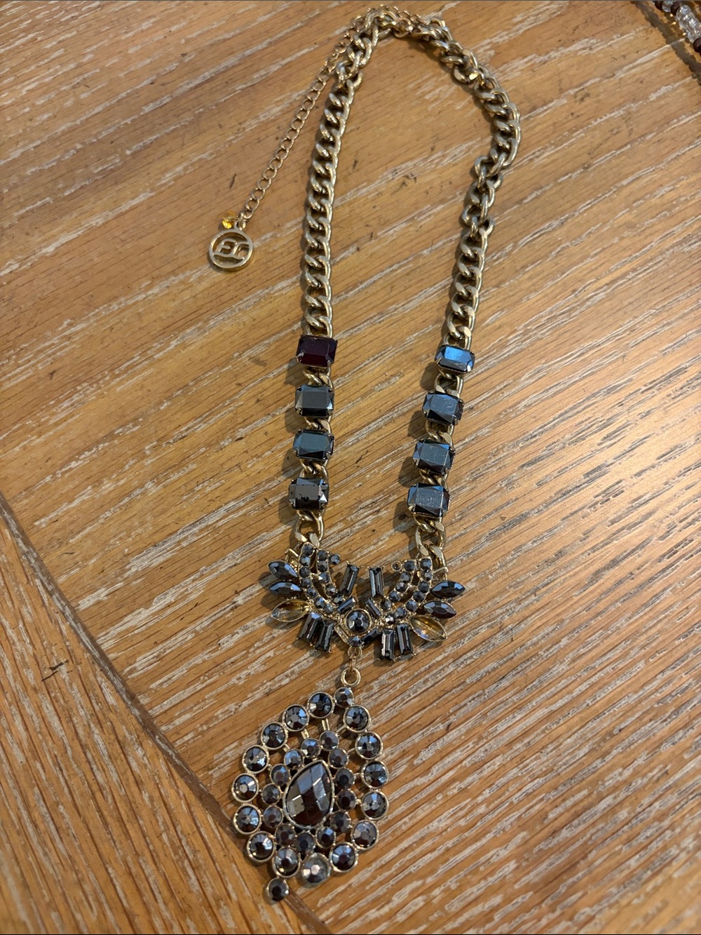This is a Erica Lyons designed necklace with gold tone, smoky grey and crystals